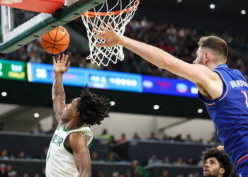 WACO, TX - FEBRUARY 01: Baylor Bears guard Robert Wright III (1) leaps for a reverse layup after driving past Kansas Jayhawks center Hunter Dickinson (1) during the Big 12 college basketball game between Baylor Bears and Kansas Jayhawks on February 1, 2025, at Foster Pavilion in Waco, Texas. (Photo by David Buono/Icon Sportswire via Getty Images)