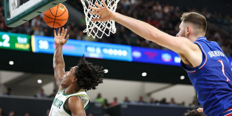 WACO, TX - FEBRUARY 01: Baylor Bears guard Robert Wright III (1) leaps for a reverse layup after driving past Kansas Jayhawks center Hunter Dickinson (1) during the Big 12 college basketball game between Baylor Bears and Kansas Jayhawks on February 1, 2025, at Foster Pavilion in Waco, Texas. (Photo by David Buono/Icon Sportswire via Getty Images)