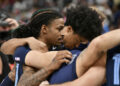 Ja Morant, Jaylen Wells and their Grizzlies teammates huddled in prayer after a fan collapsed in the stands. (AP Photo/Brandon Dill)