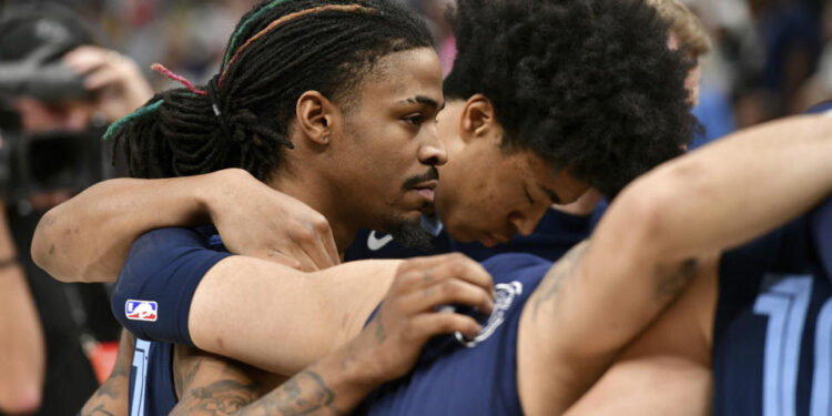 Ja Morant, Jaylen Wells and their Grizzlies teammates huddled in prayer after a fan collapsed in the stands. (AP Photo/Brandon Dill)