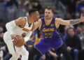 Denver Nuggets guard Russell Westbrook, left, looks to pass the ball as Los Angeles Lakers.