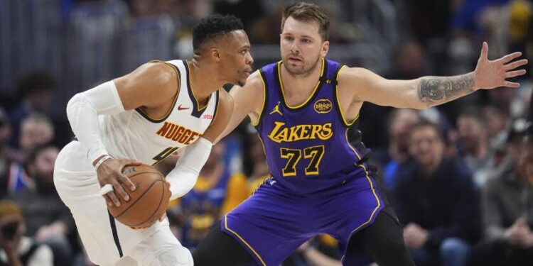 Denver Nuggets guard Russell Westbrook, left, looks to pass the ball as Los Angeles Lakers.