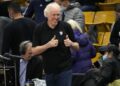 Television announcer Bill Walton acknowledges fans at an NCAA college basketball game.