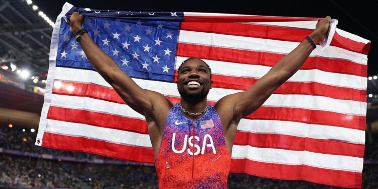 Noah Lyles holds an American flag