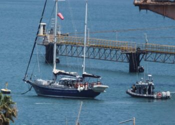 Gaza-bound British-flagged yacht "Madleen" is docked next to a military boat Ashdod port following a takeover by the Israeli army, in Ashdod, Israel, June 10, 2025 [Nir Elias/Reuters]
