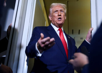 U.S. President Donald Trump speaks to members of the media on board Air Force One en route to the U.S