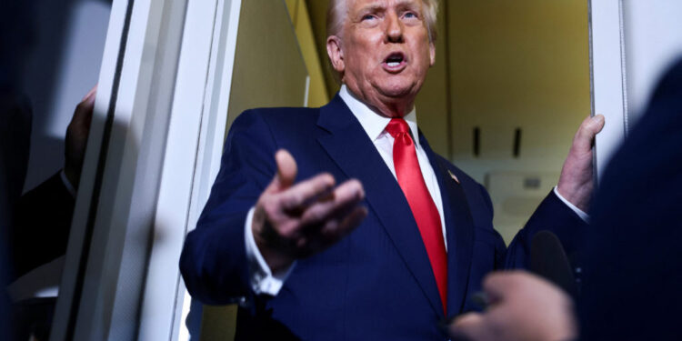 U.S. President Donald Trump speaks to members of the media on board Air Force One en route to the U.S