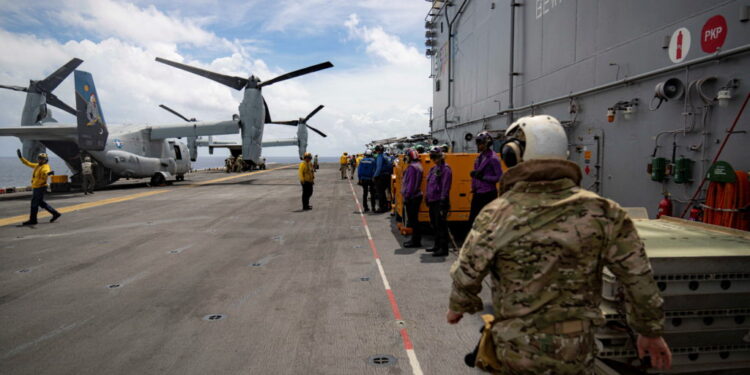 A pair of MV-22 Osprey transport aircraft are parked aboard the U.S. Navy amphibious assault ship USS Iwo Jima in the Cari...