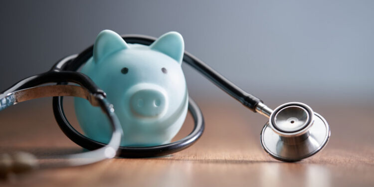 Close-up of piggy bank with stethoscope on table