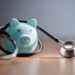 Close-up of piggy bank with stethoscope on table
