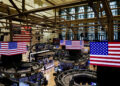 FILE PHOTO: American flags are displayed on screens on the floor at the New York Stock Exchange (NYSE) in New York City