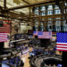 FILE PHOTO: American flags are displayed on screens on the floor at the New York Stock Exchange (NYSE) in New York City
