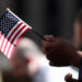 A citizenship candidate holds a flag during the U.S. Citizenship and Immigration Services (USCIS) naturalization ceremony ...