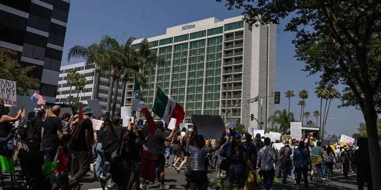 Community members take part in the Dena Protest that started a Pasadena City Hall and walked by four hotels, the Dena Hotel Pasadena, Hilton Pasadena, AC Hotel Pasadena, Westin Hotel Pasadena, in the area that housed ICE officials