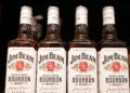 Bottles of Jim Beam are displayed on a shelf in a supermarket