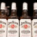 Bottles of Jim Beam are displayed on a shelf in a supermarket