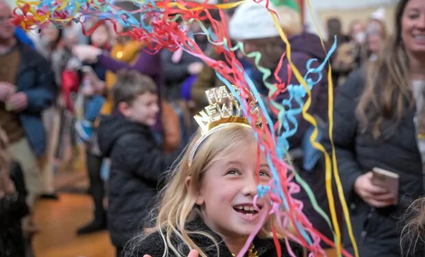 Maisie Holl, 8, of Ellicott City slingsconfetti above her head as the Noon Year's Eve ball drop count, a kid-friendly celebration to ring in 2026 completes at B&O Railroad Museum. (Karl Merton Ferron/Staff)