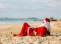 Summer Santa lying on the beach