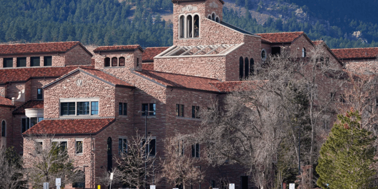 Student walking on campus of University of Colorado Boulder