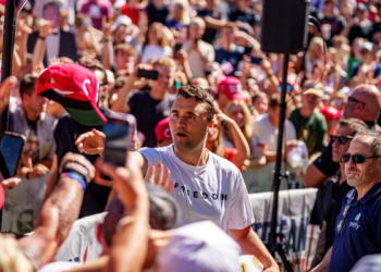 Charlie Kirk surrounded by a large audience, tosses hats to the crowd shortly before his assassination in Utah
