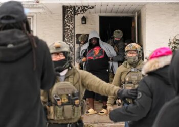 ADDS IDENTIFICATION: Garrison Gibson is arrested by federal immigration officers Sunday, Jan. 11, 2026, in Minneapolis. (AP Photo/John Locher)
