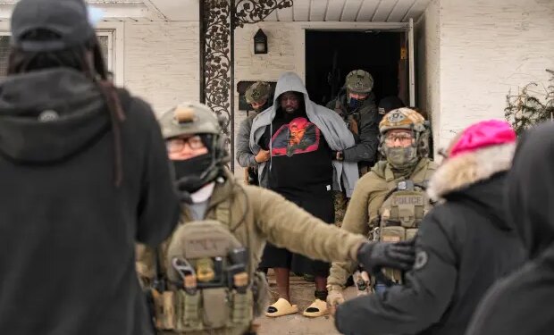 ADDS IDENTIFICATION: Garrison Gibson is arrested by federal immigration officers Sunday, Jan. 11, 2026, in Minneapolis. (AP Photo/John Locher)