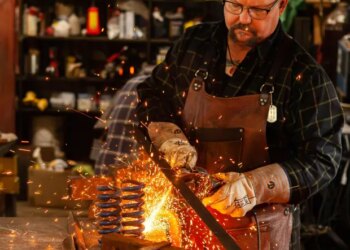 Steve Kost, of Palos Park, works on "Heavy Hearts," a sculpture made from metal and found objects. The former Navy Seabee was among artists showing work at the first display of art by veterans last year at McCord Gallery & Cultural Center in Palos Park. (Daniel Cherry)