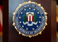 FILE - An FBI seal is displayed on a podium before a news conference at the field office in Portland, Ore., Jan. 16, 2025. (AP Photo/Jenny Kane, File)