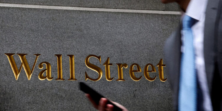 FILE PHOTO: A man walks on Wall St. outside the NYSE in New York
