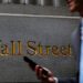 FILE PHOTO: A man walks on Wall St. outside the NYSE in New York