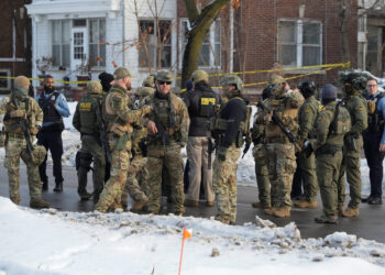 Members of U.S. Immigration and Customs Enforcement (ICE) gather at the scene where a driver was shot by a U.S. immigratio...
