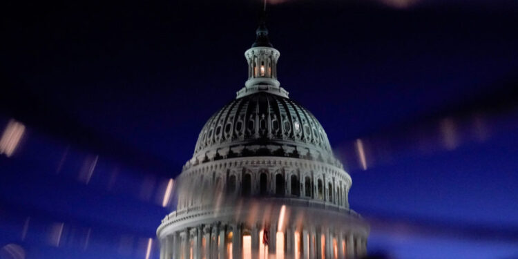 FILE PHOTO: The U.S. Capitol dome is seen reflected in a puddle in Washington