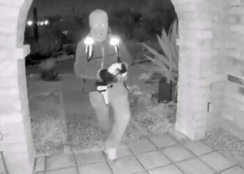 A view from a doorbell camera showing an armed individual outside the residence of Nancy Guthrie in Tucson, Arizona