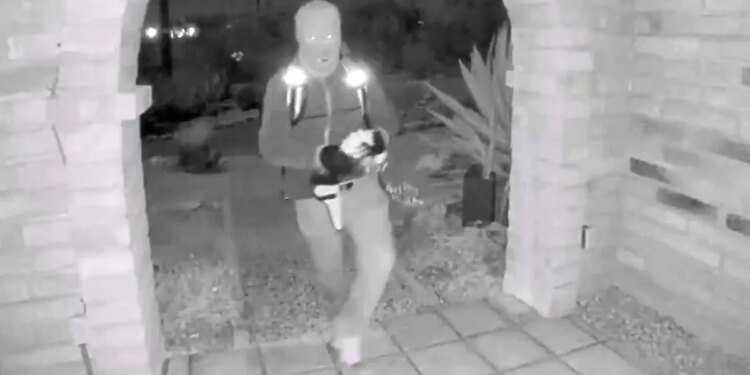 A view from a doorbell camera showing an armed individual outside the residence of Nancy Guthrie in Tucson, Arizona