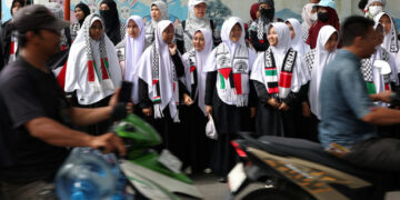 Women in solidarity with Palestinians take part in a protest outside the Palestinian Embassy in Jakarta