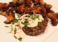 Quinoa patties are served with chanterelles and topped with tahini sauce. (Photo by Yakir Levy)
