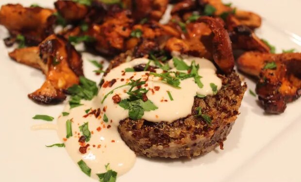 Quinoa patties are served with chanterelles and topped with tahini sauce. (Photo by Yakir Levy)