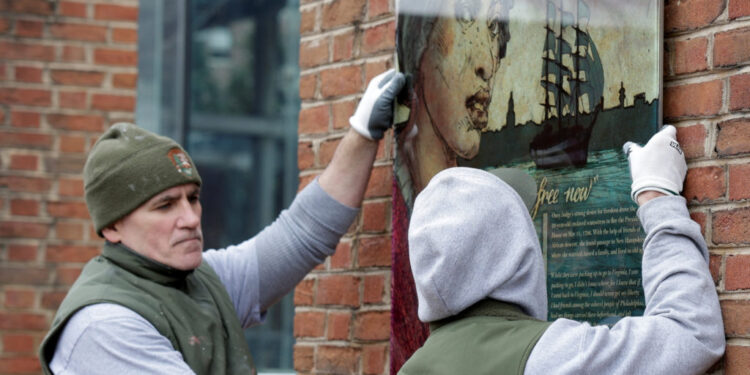 Workers from the National Park Service reinstall a slavery exhibit at a historic site in Philadelphia