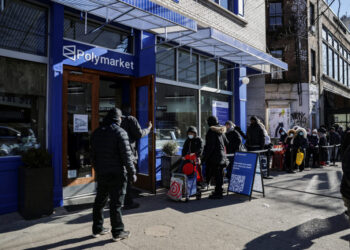 People wait in line to enter a free grocery store launched by Polymarket in New York City