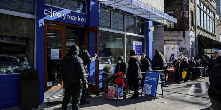 People wait in line to enter a free grocery store launched by Polymarket in New York City