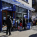 People wait in line to enter a free grocery store launched by Polymarket in New York City