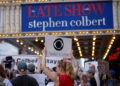FILE PHOTO: People protest after CBS/Paramount announced the cancellation of The Late Show with Stephen Colbert in New York