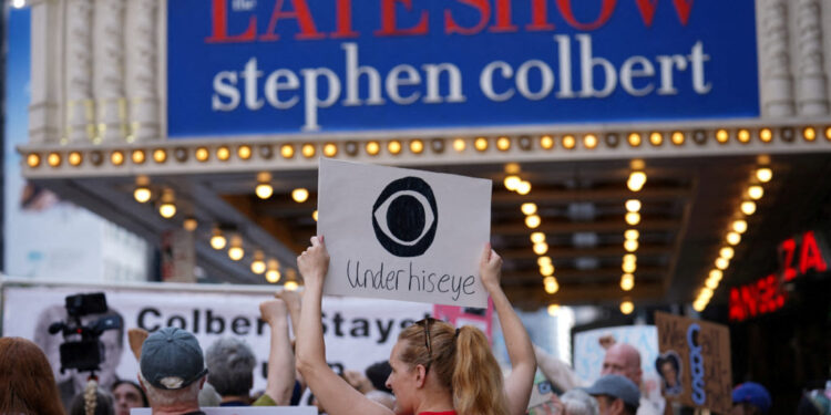 FILE PHOTO: People protest after CBS/Paramount announced the cancellation of The Late Show with Stephen Colbert in New York