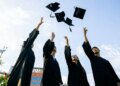 students tossing graduation caps