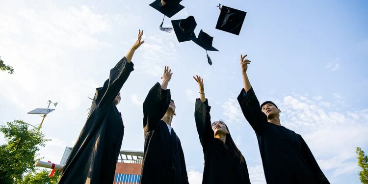 students tossing graduation caps