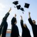 students tossing graduation caps