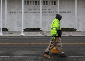 A worker walks in front of the recently renamed Donald J. Trump and John F. Kennedy Memorial Center for the Performing Art...