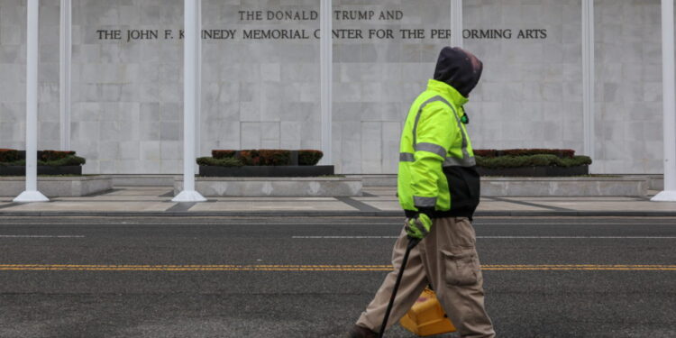 A worker walks in front of the recently renamed Donald J. Trump and John F. Kennedy Memorial Center for the Performing Art...
