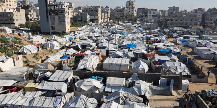 Palestinians displaced during the two-year Israeli offensive, shelter at a tent camp in Gaza City
