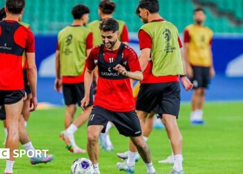 Iraq national team players warm-up on a football pitch